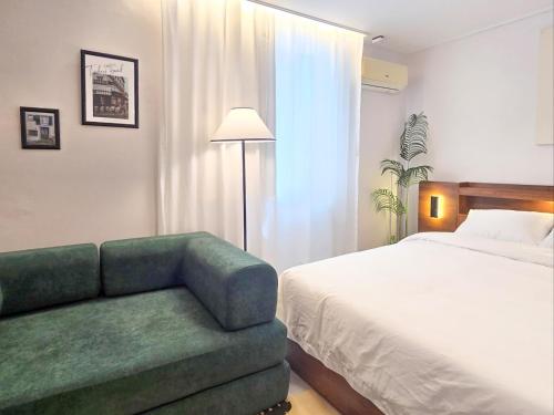 a bedroom with a bed and a green couch at 스테이동백 in Jeonju