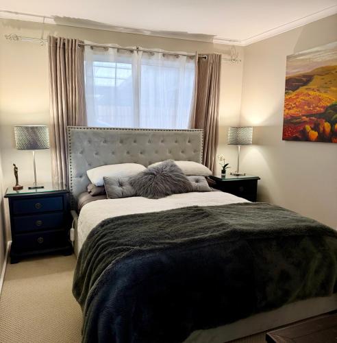 a bedroom with a large bed with two night stands at Stylish 2-Bed Home, Stunning View, Fire Pit, Festoon Lights, BBQ and walk to Pub in Poowong