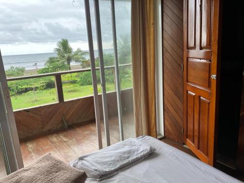 a bedroom with a bed and a view of the ocean at Villa Encanto in Bahía Solano