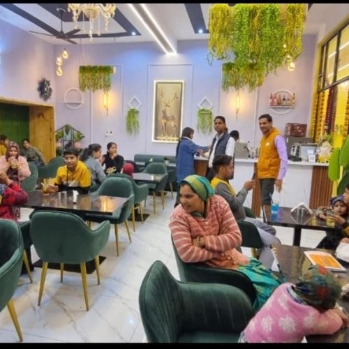 a group of people sitting at tables in a restaurant at Hotel gl palace & restaurant chomu in Jaipur