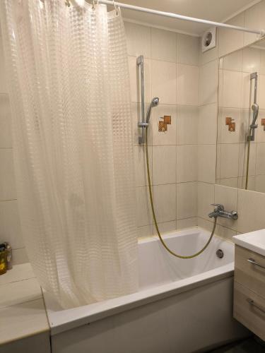 a bathroom with a shower and a tub with a shower curtain at Family Apartament in Narva-Jõesuu