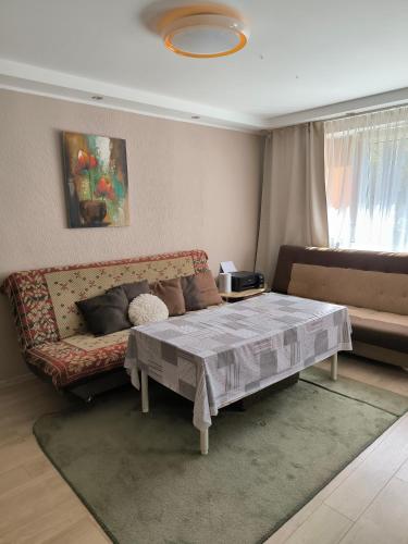 a living room with a bed and a couch at Family Apartament in Narva-Jõesuu