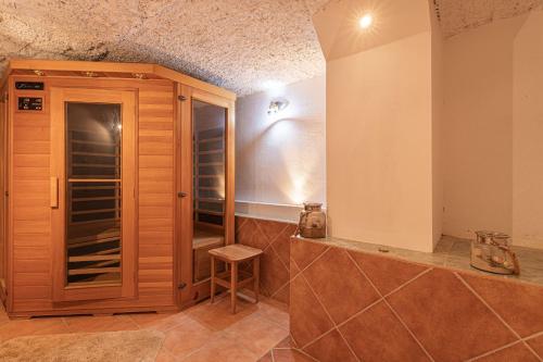 a kitchen with a wooden cabinet and a stool at House Fortin With Sauna Near Bloke Lake - Happy Rentals in Velike Bloke