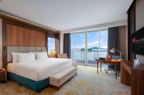a hotel room with a bed and a desk at Swiss-Belhotel Papua in Jayapura