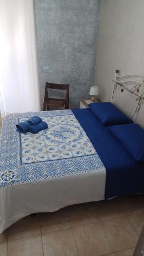 a bedroom with a bed with a blue comforter at Perla del mare Ionio in Fondachello