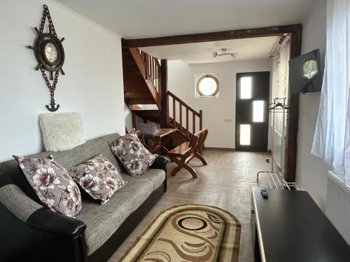 a living room with a couch and a clock on the wall at Apartaments Doriana in Vama Veche