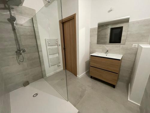 a bathroom with a shower and a sink and a mirror at Villa Casa di sognu in Lecci