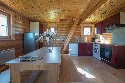 een keuken met een houten plafond en een houten tafel bij Ranch des bisons in Petit-Réderching