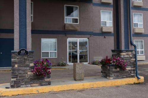 a building with two flowers in front of it at Super 8 by Wyndham Whitecourt in Whitecourt