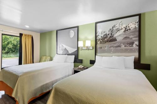 two beds in a hotel room with green walls at Super 8 by Wyndham Acworth/Atlanta Area in Acworth