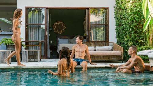 a group of people sitting in a swimming pool at Karma House Ungasan in Jimbaran