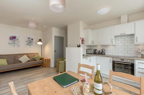 uma cozinha e sala de estar com uma mesa com uma garrafa de vinho em The Wee Thistle em Edimburgo
