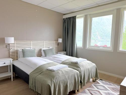 ein weißes Schlafzimmer mit einem großen Bett und einem Fenster in der Unterkunft Sogn Hotel in Vadheim