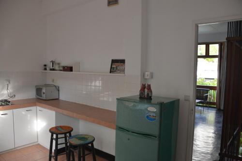 a kitchen with a green refrigerator and two stools at Flower Road Villa in Colombo