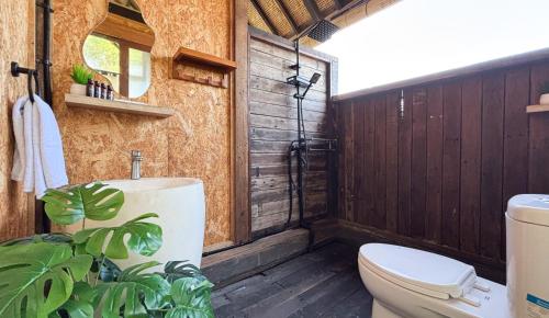 a bathroom with a toilet and a shower at Salty Cabin Sunset Views Yeh Leh Beach in Balian