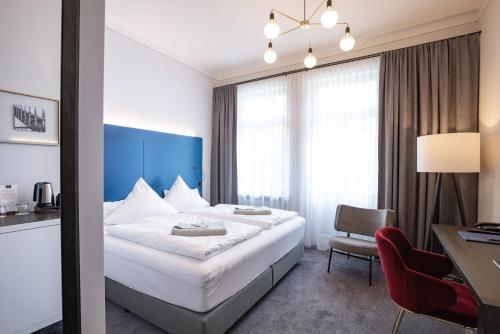 a hotel room with a bed and a desk and a chair at Villa Rein Boutiquehotel in Bad Reichenhall