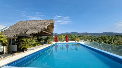 a pool at a resort with mountains in the background at Villas Boutique Casa Ricarda in Aticama
