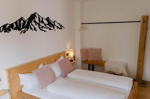 a bedroom with a bed with white and pink pillows at Ferienwohnung Enzian in Halblech