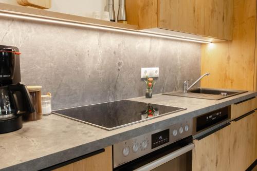 a kitchen with a sink and a stove at Ferienwohnung Enzian in Halblech