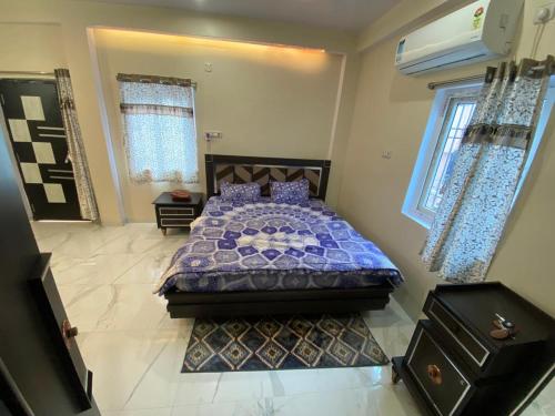 a bedroom with a bed with a purple comforter at Vedavit Bhavanam in Gaya