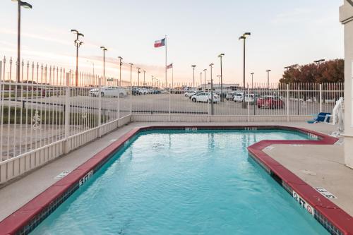 a swimming pool in a parking lot with cars at Motel 6-Fort Worth, TX - White Settlement in Fort Worth