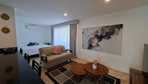 a hotel room with a bed and a couch and a table at Villas Boutique Casa Ricarda in Aticama