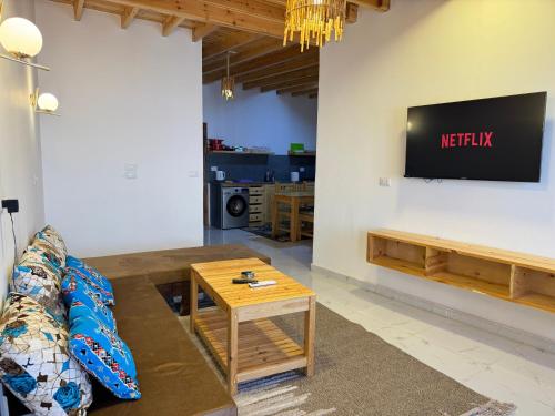 a living room with a couch and a tv on a wall at Blue Villa in Lighthouse in Dahab