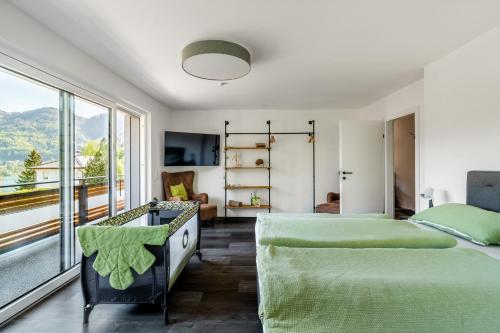 a bedroom with two beds and a large window at Seeblick Homes in Fuschl am See