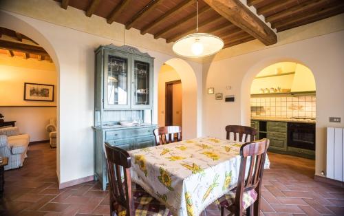 a dining room with a table and a kitchen at Carlino Vacanze in Gaiole in Chianti