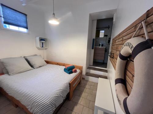 a small bedroom with a bed and a mirror at Une pause vacances in Bandol