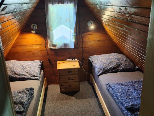 a attic room with two beds and a window at Nyírfa vendégház in Fadd-Dombori