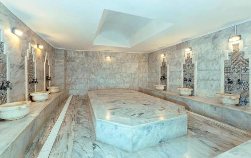 a bathroom with four toilets and a large tub at Sealight Resort Hotel in Kuşadası