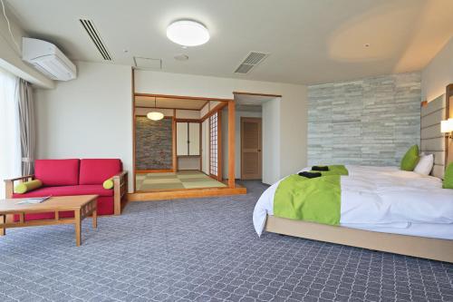 a bedroom with a large bed and a red couch at Satsuma Resort Hotel in Satsuma