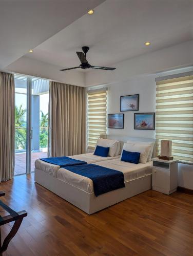 a bedroom with a large bed with a ceiling fan at Oceanfront condo 3-2-01- Nilaveli in Nilaveli