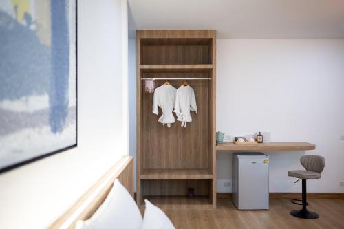 a room with a closet with white clothes at Plerntaan HoReCa in Ban Khlong Kum