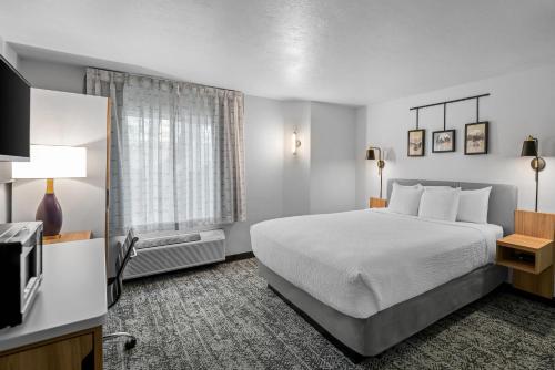 a hotel room with a bed and a television at Sleep Inn near Washington State Line in Post Falls