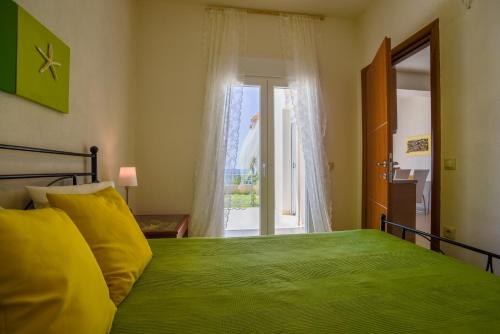 a bedroom with a green bed and a window at Into The Blue in Agia Paraskevi