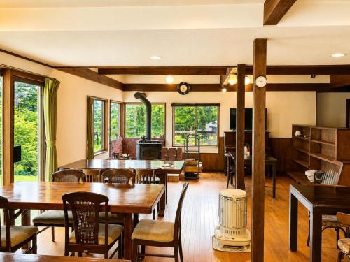 a living room with tables and chairs and a stove at Komorebi Myoko Lodge in Myoko