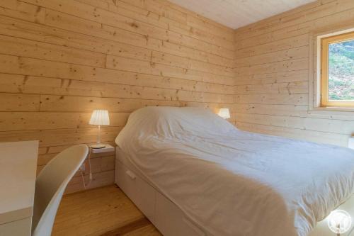 a bedroom with a bed and a desk and a window at Le grand tétras in Boutx