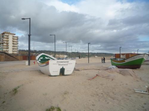 two boats sitting on the sand on a beach at Casa Mar in Costa da Caparica