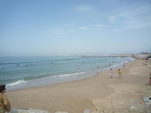 a group of people walking on the beach at Casa Mar in Costa da Caparica