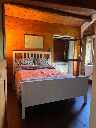 a bedroom with a white bed in a wooden room at The Bookhouse Home Bb in Poggio San Marcello 