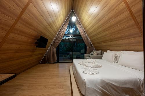 a bed in a room with a wooden ceiling at Plerntaan HoReCa in Ban Khlong Kum