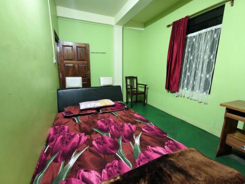 a bedroom with a bed with purple flowers on it at itynnad homestay in Shillong