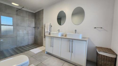 a bathroom with two sinks and a shower at Apollo on Sea in Velddrif