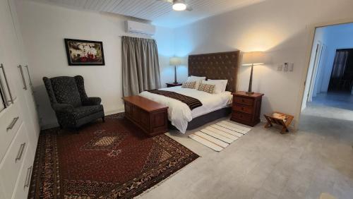a bedroom with a bed and a chair in it at Apollo on Sea in Velddrif