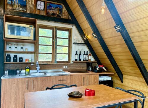 a kitchen with a wooden table and a sink at Chalé amanhecer in Cobras