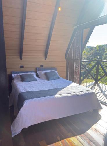 a bedroom with a bed and a balcony at Chalé amanhecer in Cobras