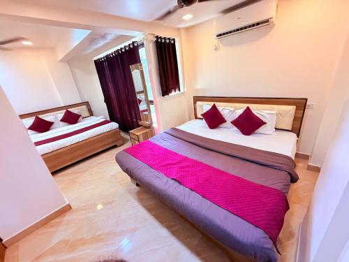 a bedroom with two beds with red pillows at Hotel Kings Residency Panvel in Navi Mumbai