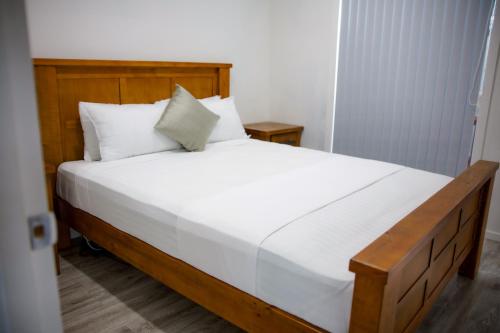 a bedroom with a large bed with white sheets and pillows at Taisia & Liku Homes in Nuku‘alofa